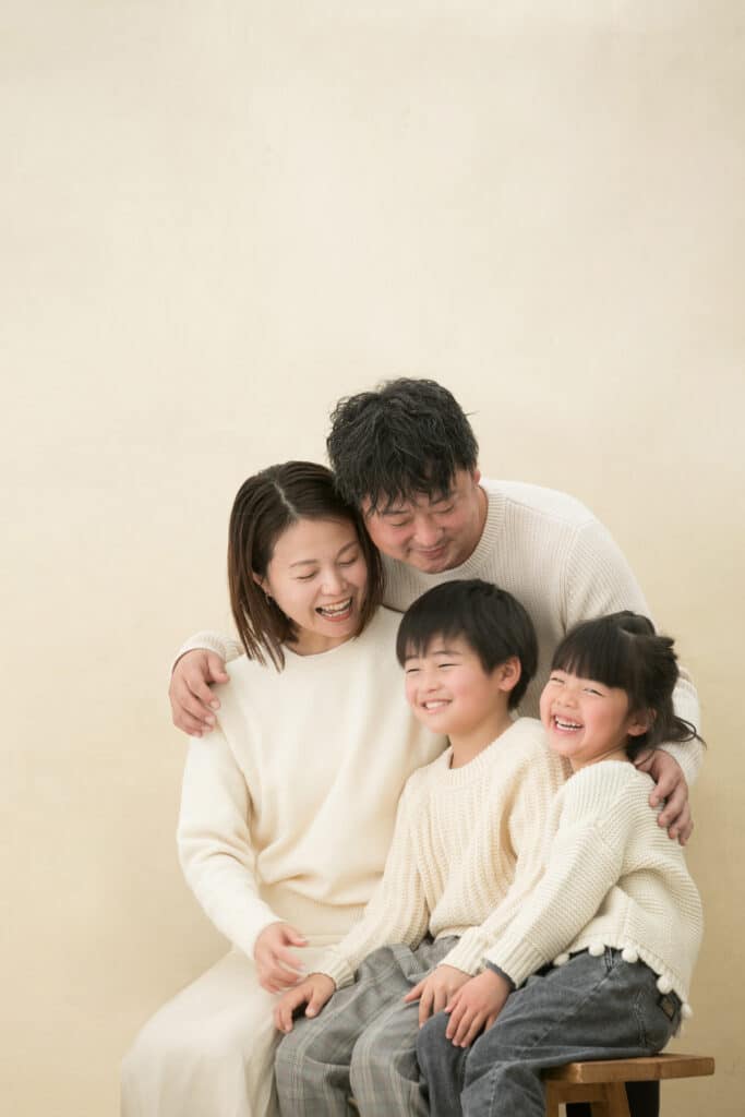 能登地震チャリティー撮影会で白い服で統一して家族写真に写る笑顔の家族